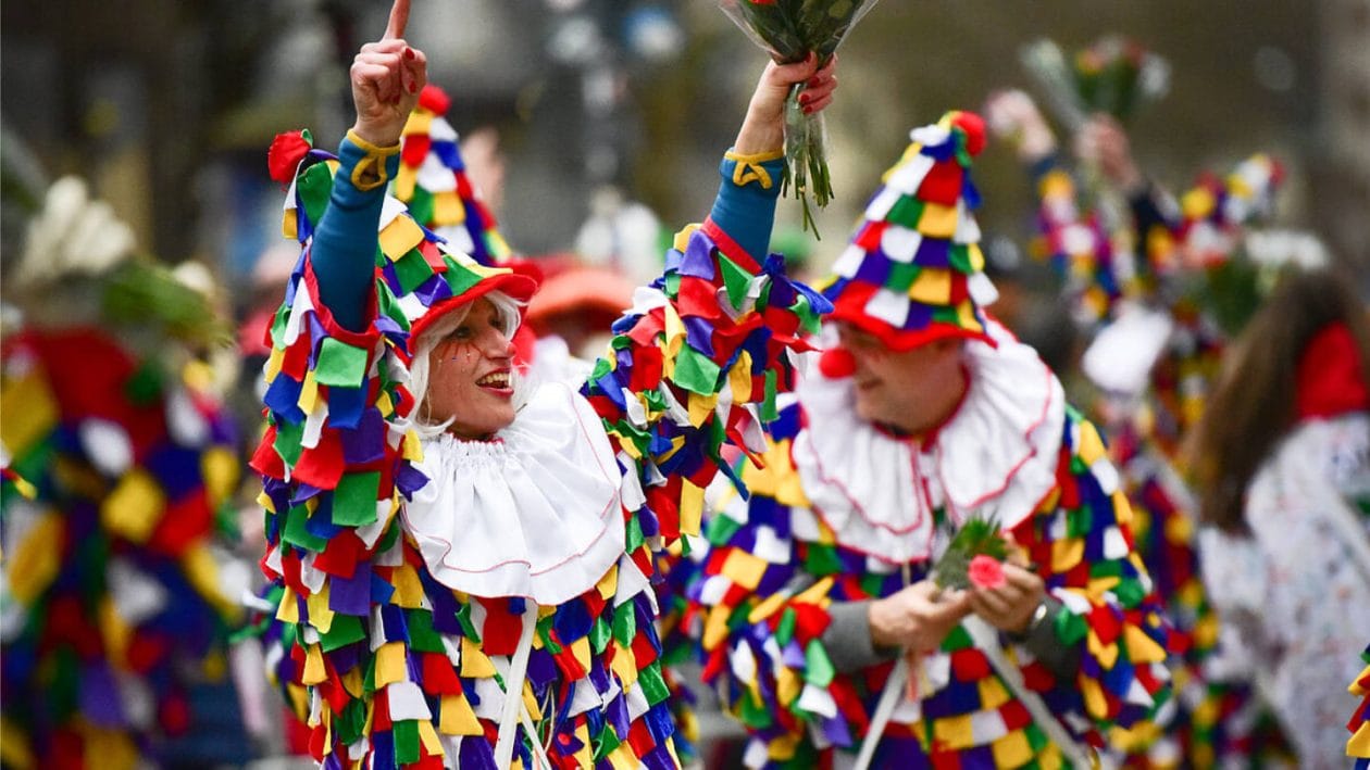 Als Clowns verkleidete Menschen feiern beim Karneval in Köln.