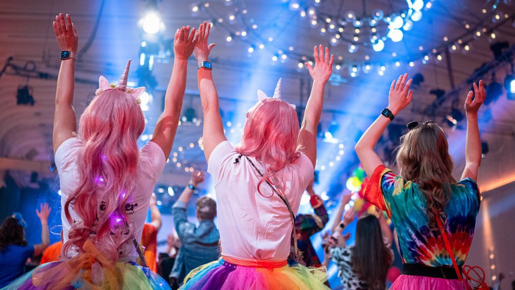 verkleidet Menschen von hinten werfen beim Kölner Karneval ihre Arme in die Luft