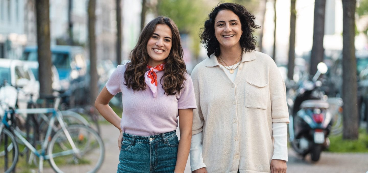 Mona Ameziane und Tuğba Tekkal stehen auf einer Straße in Köln und schauen in die Kamera