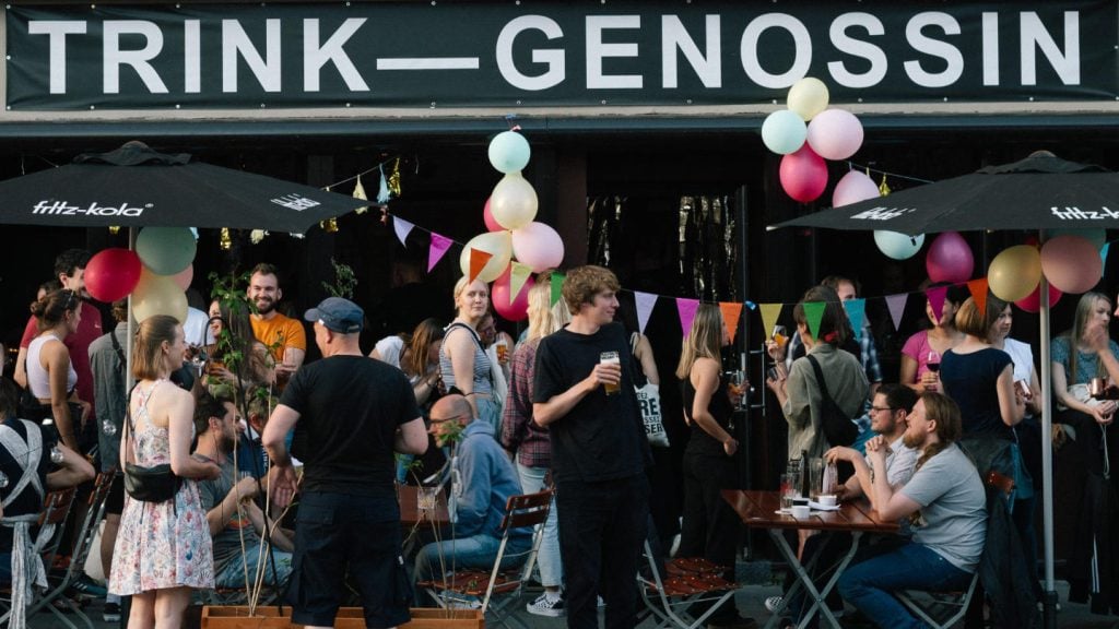 Terrasse der Bar Trink-Genossin in Köln mit vielen Menschen, die Bier trinken