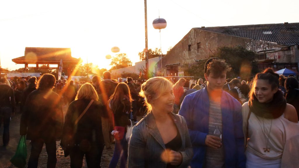 Menschen laufen über den Nachtkonsum Flohmarkt in Köln während die Sonne untergeht
