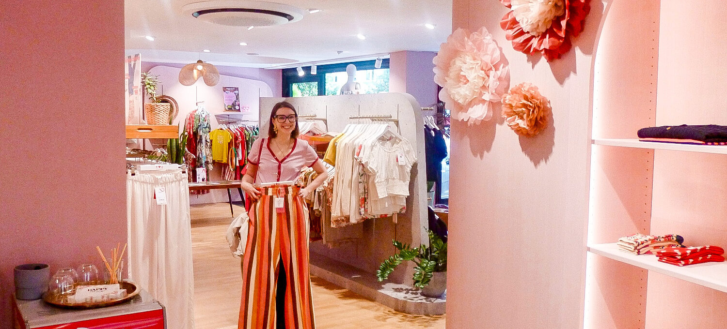Shoppingtour: Tamina Orenda betrachtet sich mit einer neuen Hose im Spiegel eines Modegeschäfts